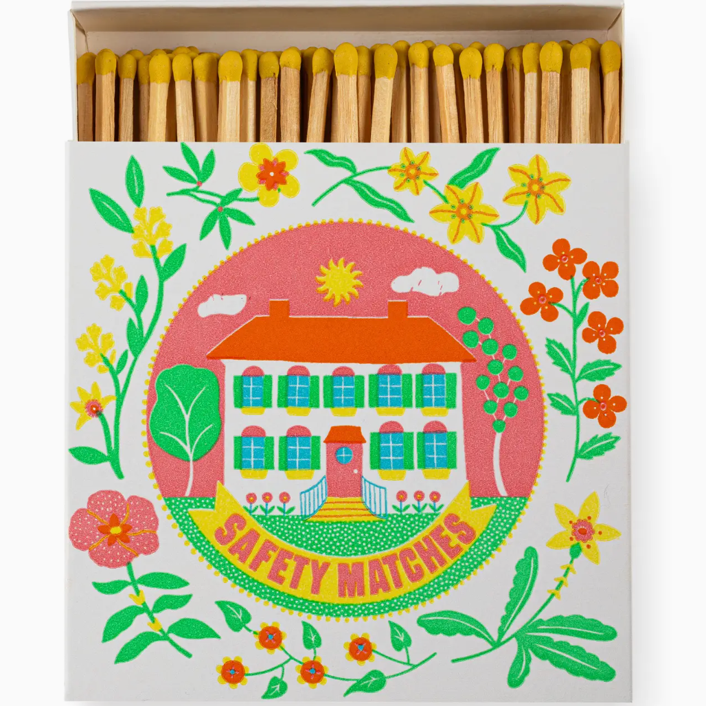 Matches with decorative packaging featuring a house and flowers on a white background