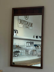 Mirror reflecting a store interior with visible branding