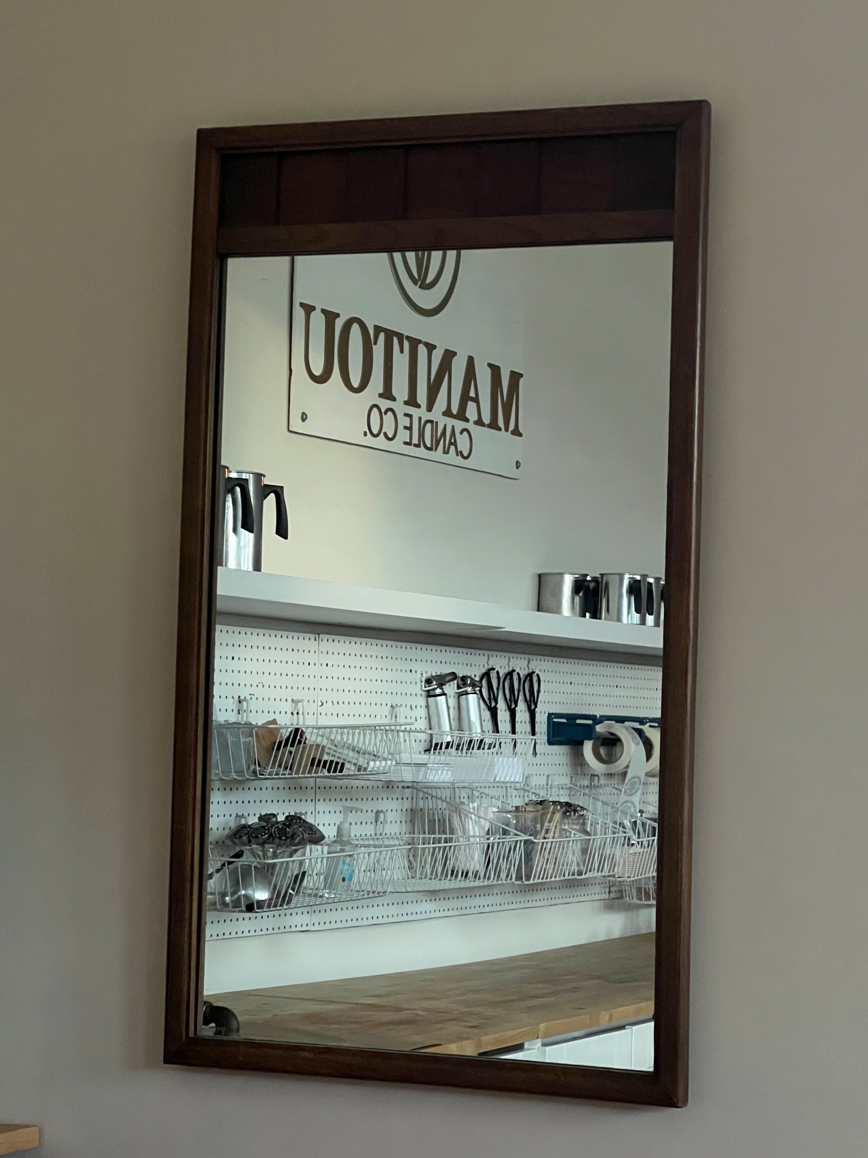 Mirror reflecting a store interior with visible branding