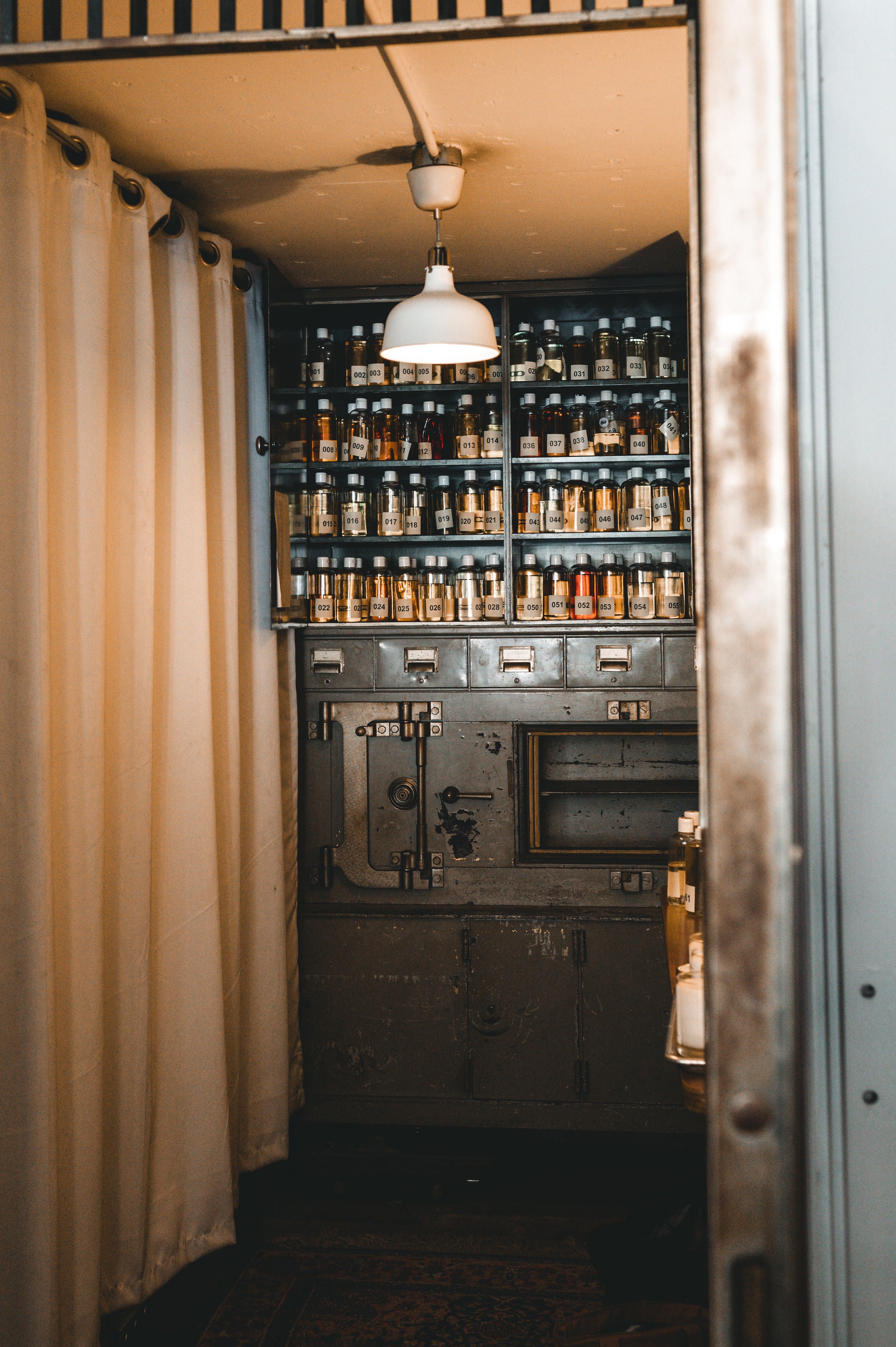 Vintage-style interior with a large safe and shelves filled with bottles.