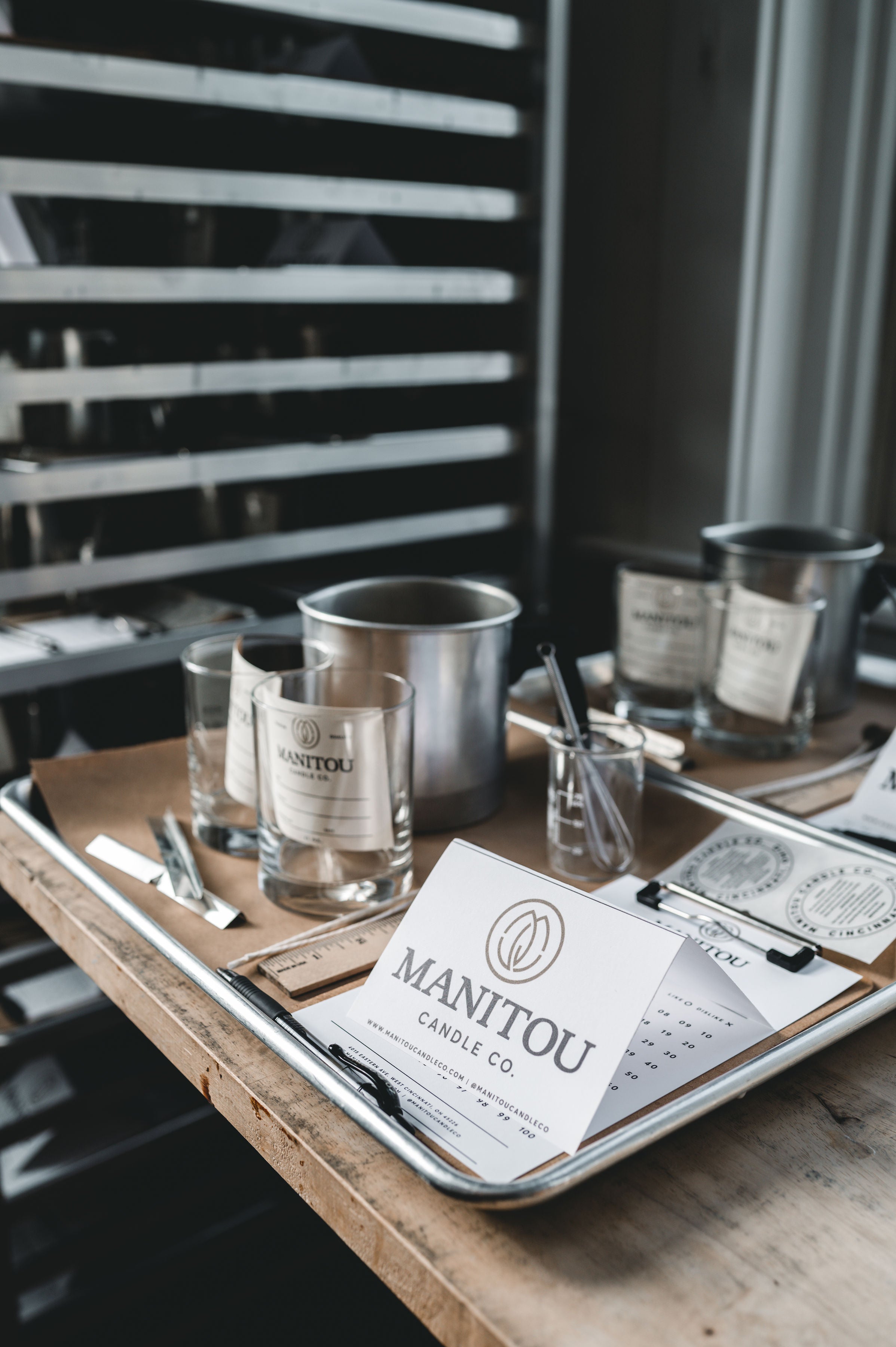 Manitou Candle Co products on a wooden tray with blurred background