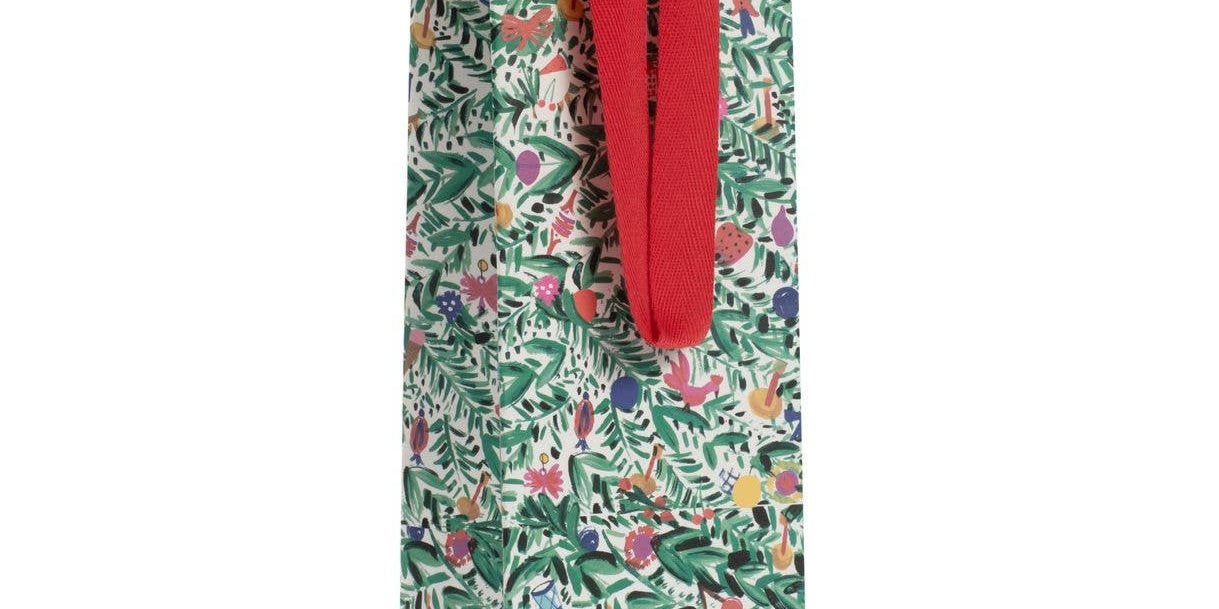 A gift bag with a Christmas-themed pattern featuring holiday tinsel and trees, and red ribbon handles.