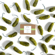 Green pickle-shaped ornaments with a box labeled 'Pickle' on a white background