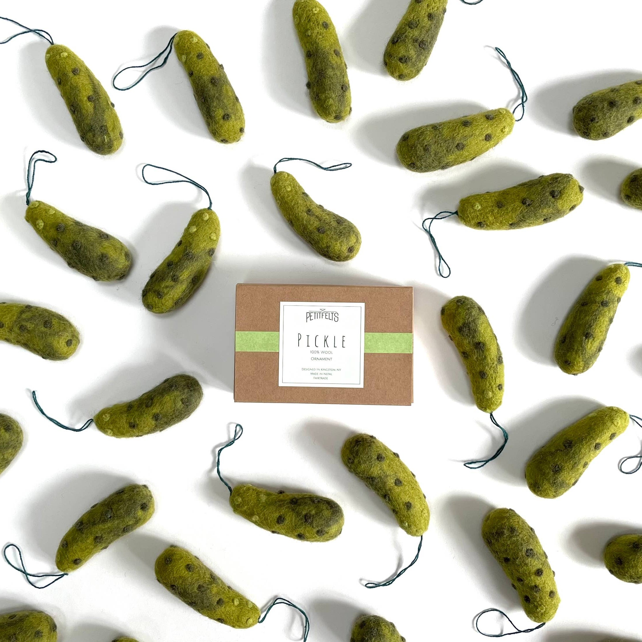 Green pickle-shaped ornaments with a box labeled 'Pickle' on a white background